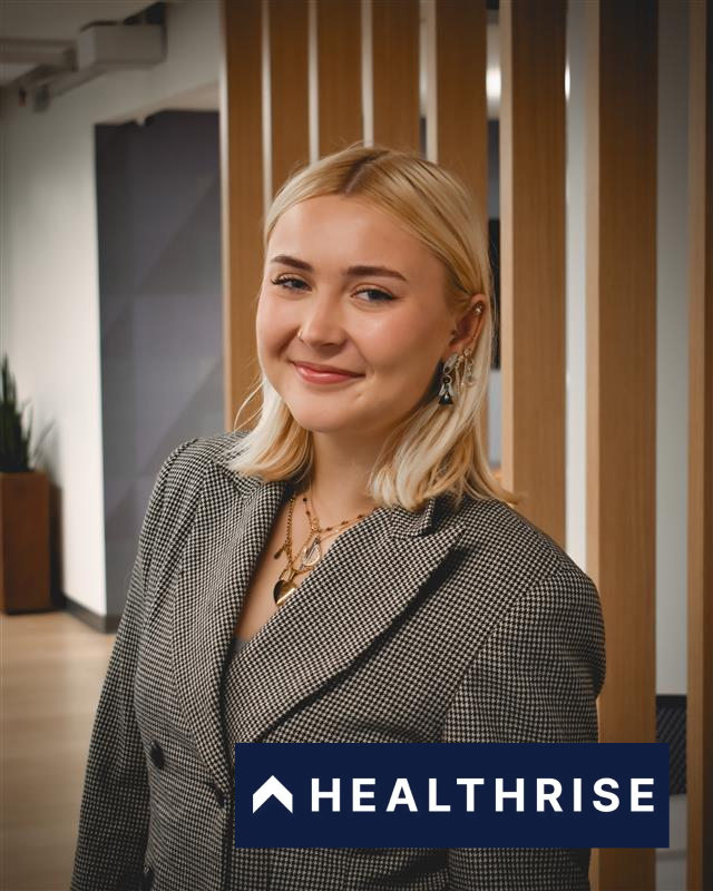 Woman in a suit with the Healthrise logo. 