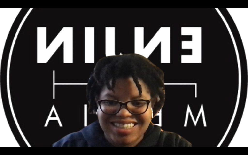 Woman smiling at the camera in front of an Enjin Media logo Zoom background.